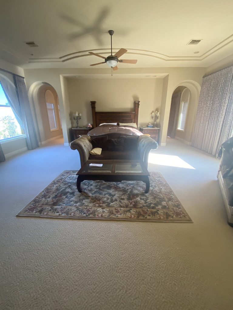 Spacious master bedroom with bed and ceiling fan
